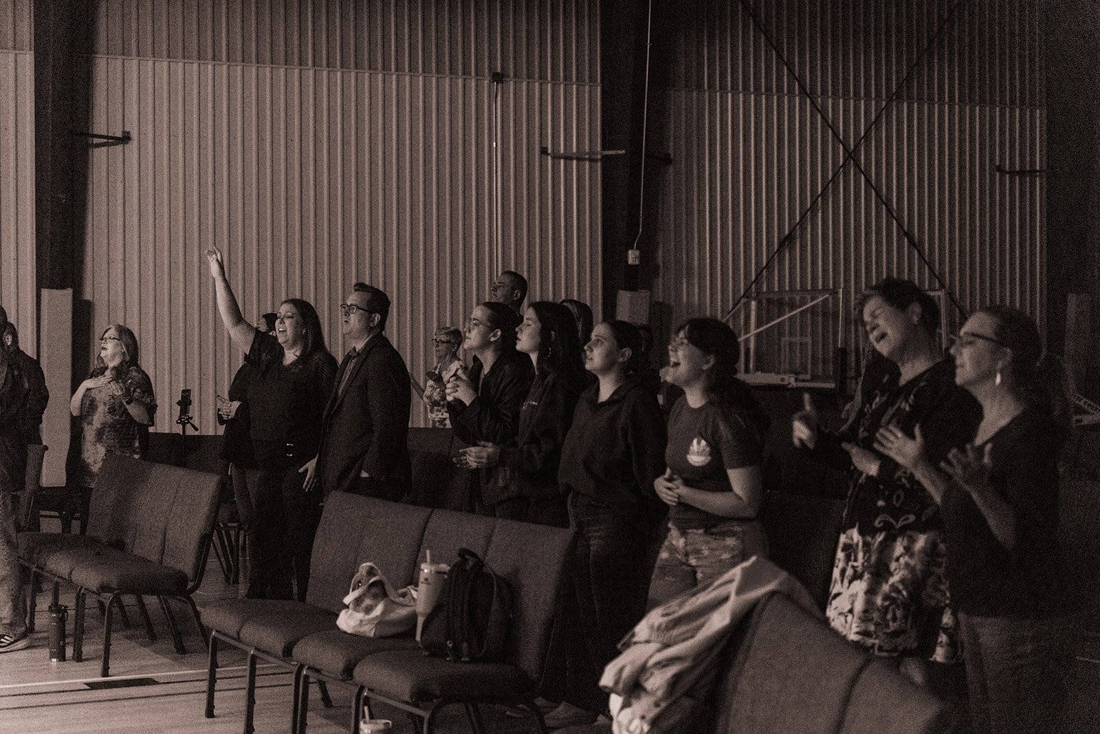 Sepia photo of the congregation standing and singing together during worship