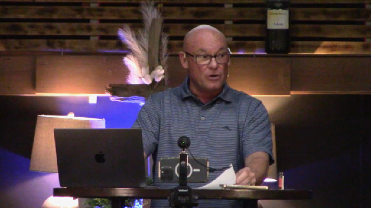 PJ: a man in glasses and a striped polo shirt speaking from a table with a laptop and a microphone.